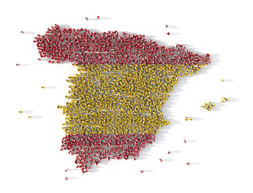 Un gran grupo de personas organizadas para formar la silueta del mapa de España, con colores rojo y amarillo que representan la bandera española